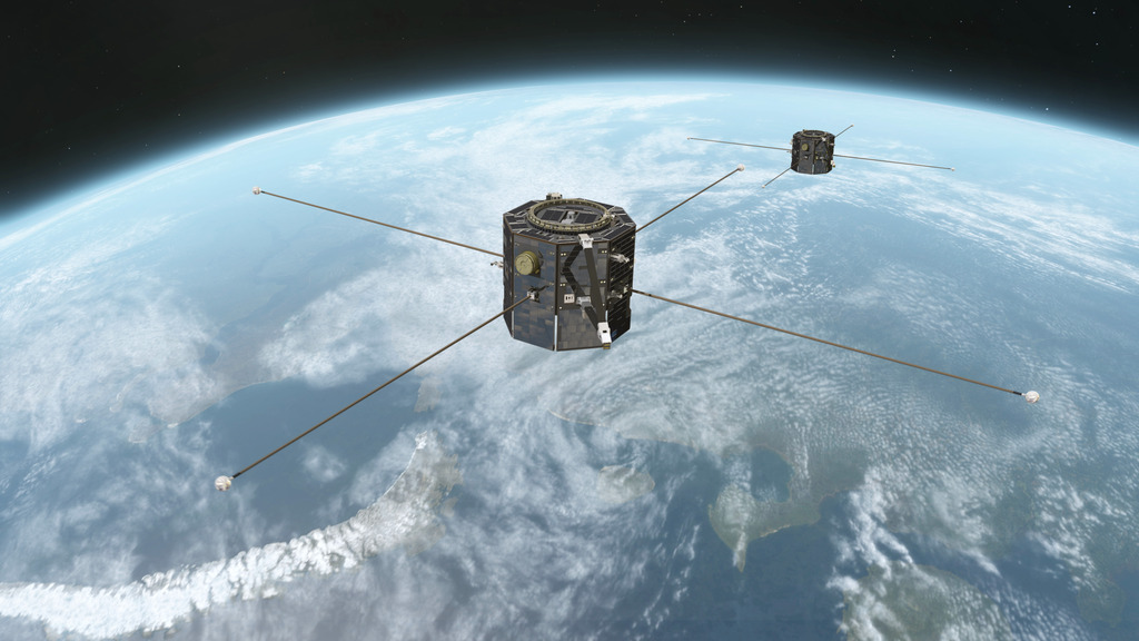 A small boxy satellite floats above Earth in space