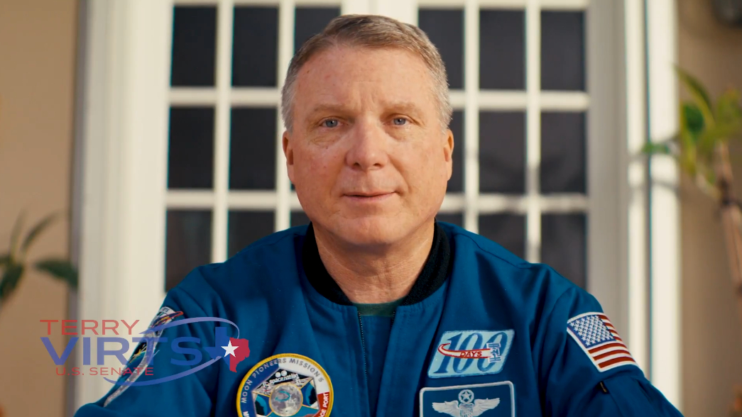 a man in blue jumpsuit looks at the camera