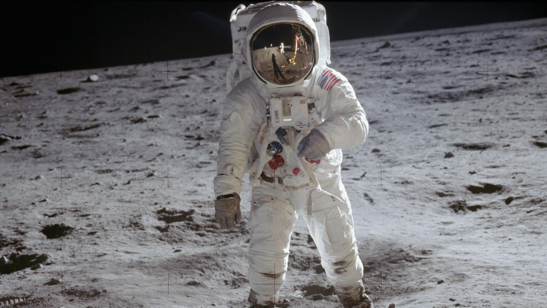 A man in a spacesuit stands on the moon
