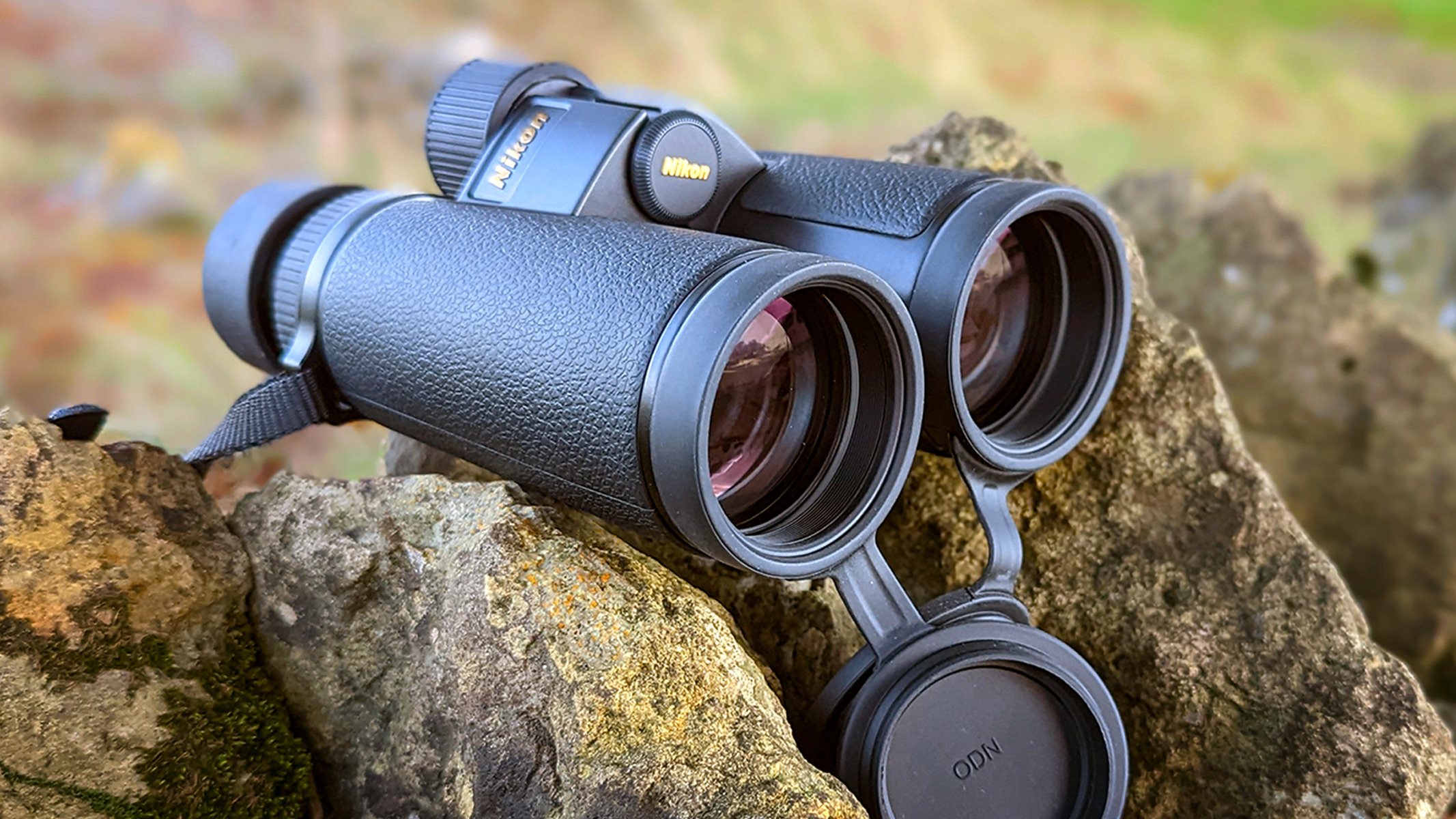 Binoculars sitting on a stone wall in the countryside